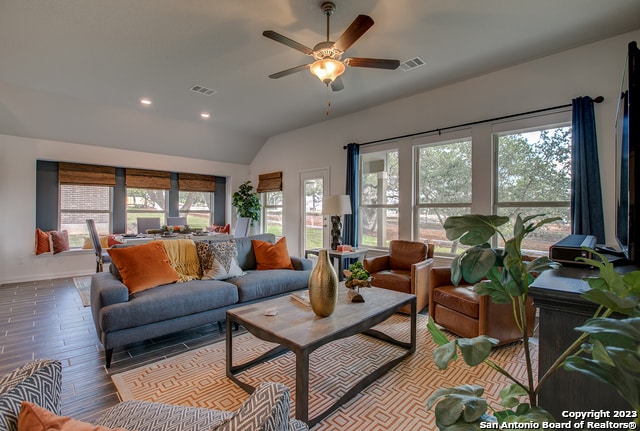 living room with vaulted ceiling, ceiling fan, and light hardwood / wood-style flooring