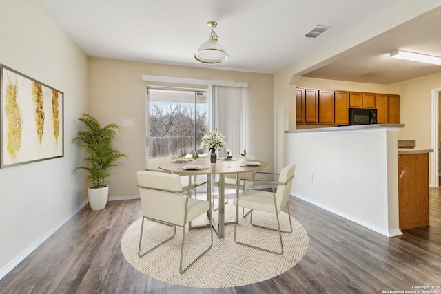 dining area with dark hardwood / wood-style floors