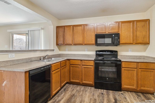 kitchen with sink, dark hardwood / wood-style flooring, and black appliances