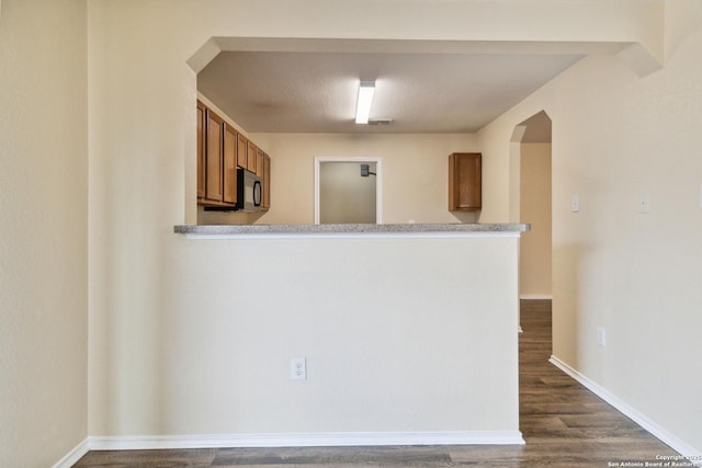 kitchen featuring dark hardwood / wood-style flooring and kitchen peninsula