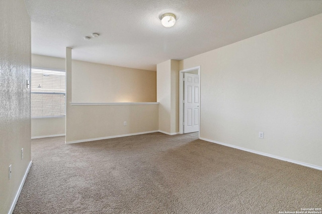 carpeted empty room featuring a textured ceiling