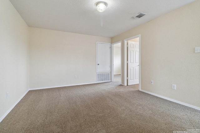 carpeted spare room featuring a textured ceiling