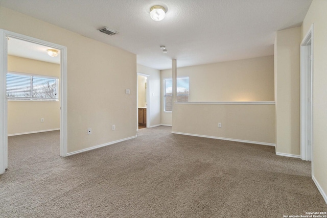 carpeted empty room featuring a textured ceiling