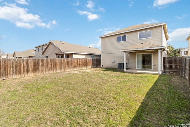 rear view of house with cooling unit, a yard, and a patio area