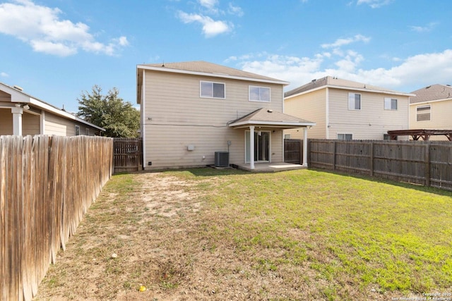 back of property with cooling unit, a yard, and a patio area