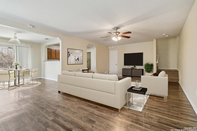 living room with dark wood-type flooring and ceiling fan