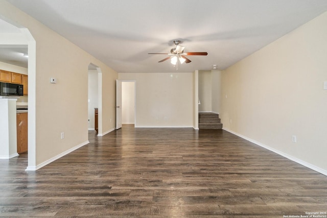 unfurnished living room featuring ceiling fan and dark hardwood / wood-style flooring