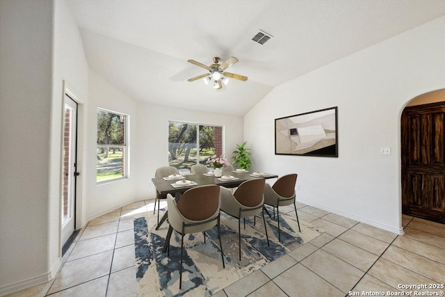 tiled dining room with lofted ceiling and ceiling fan