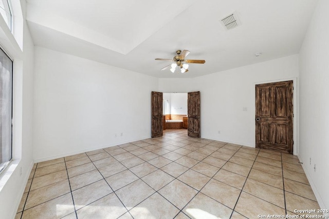 tiled empty room featuring ceiling fan