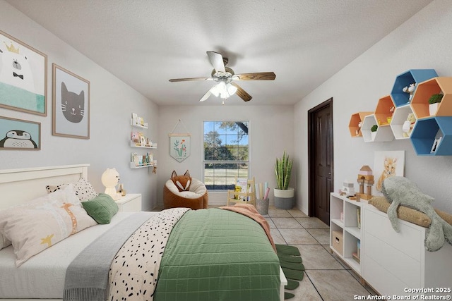 tiled bedroom featuring ceiling fan and a textured ceiling