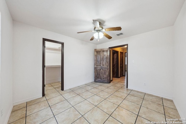 empty room featuring ceiling fan and light tile patterned floors