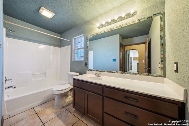 full bathroom featuring bathing tub / shower combination, vanity, a textured ceiling, tile patterned floors, and toilet