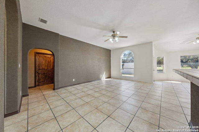 spare room with light tile patterned floors, a textured ceiling, and ceiling fan