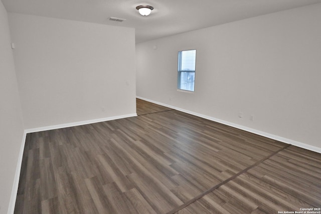 spare room with dark hardwood / wood-style flooring