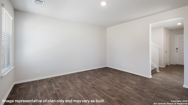 empty room with plenty of natural light and dark hardwood / wood-style flooring