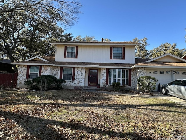 view of property featuring a garage and a front lawn