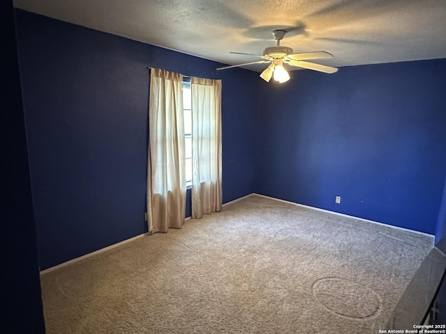 carpeted empty room with ceiling fan and a textured ceiling