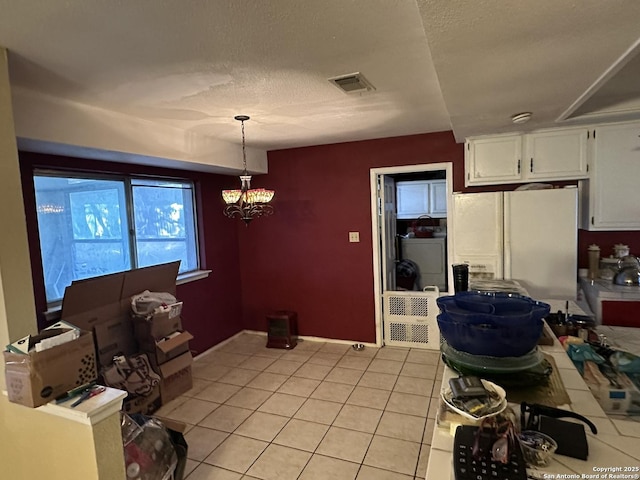 kitchen featuring light tile patterned flooring, white cabinets, a chandelier, hanging light fixtures, and white refrigerator with ice dispenser