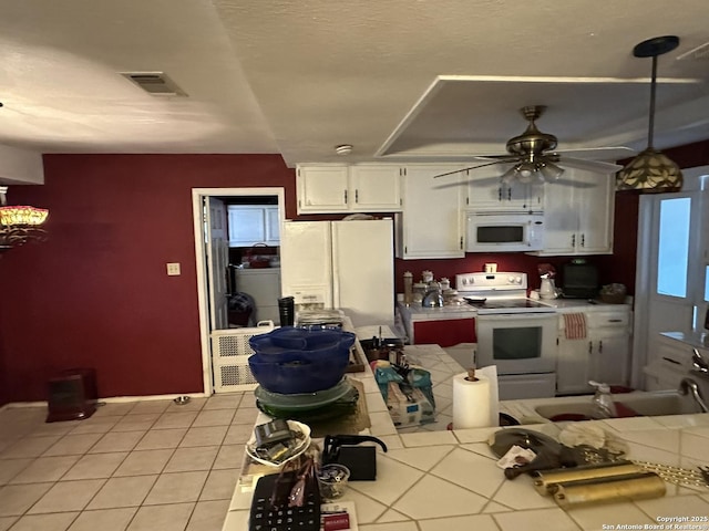 kitchen featuring white cabinetry, sink, light tile patterned floors, ceiling fan, and white appliances