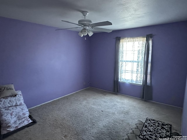 carpeted empty room featuring ceiling fan