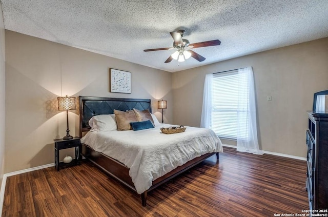 bedroom with ceiling fan, dark hardwood / wood-style floors, and a textured ceiling