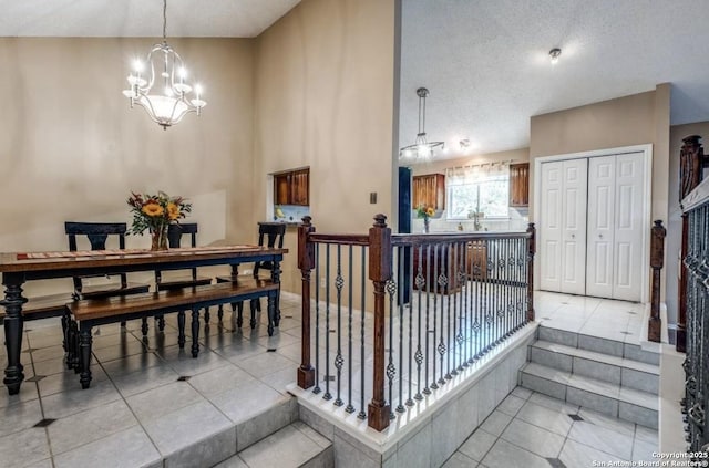 interior space with light tile patterned flooring, a textured ceiling, and a chandelier