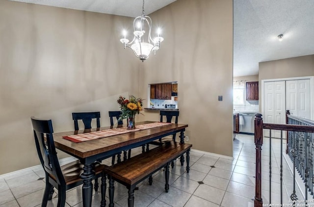 tiled dining space featuring an inviting chandelier, a towering ceiling, and a textured ceiling