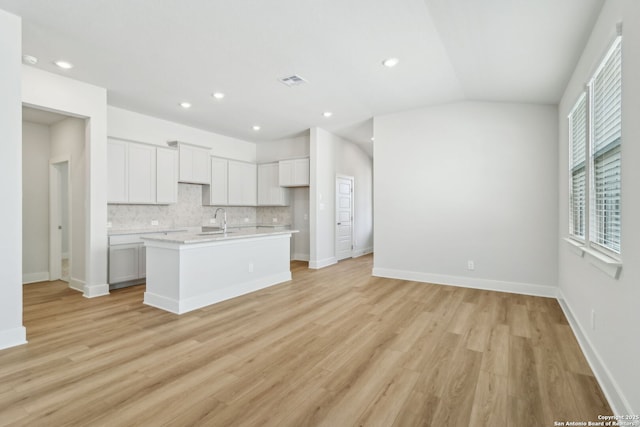 14603 Rainwater Trl, San Antonio, TX 78253 - kitchen with light countertops, lofted ceiling, decorative backsplash, a center island with sink, and visible vents
