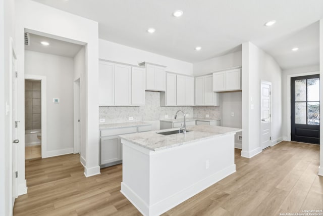 14603 Rainwater Trl, San Antonio, TX 78253 - kitchen featuring backsplash, light wood-style flooring, a sink, and a center island with sink