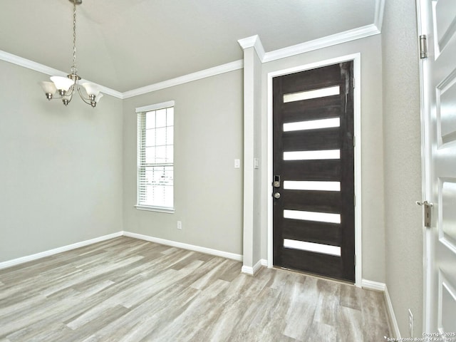 entryway with an inviting chandelier, ornamental molding, and light wood-type flooring