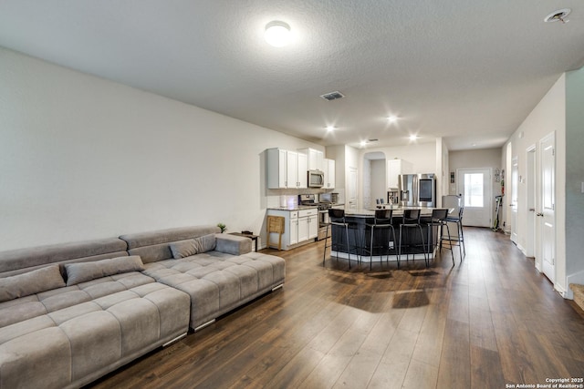 living room with dark hardwood / wood-style flooring and a textured ceiling