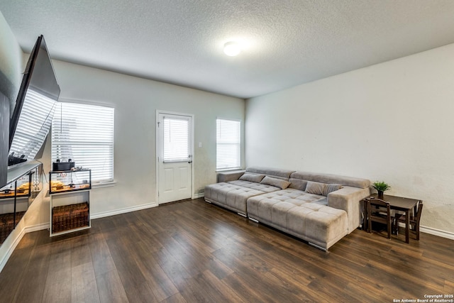 living room featuring dark wood-type flooring and a textured ceiling