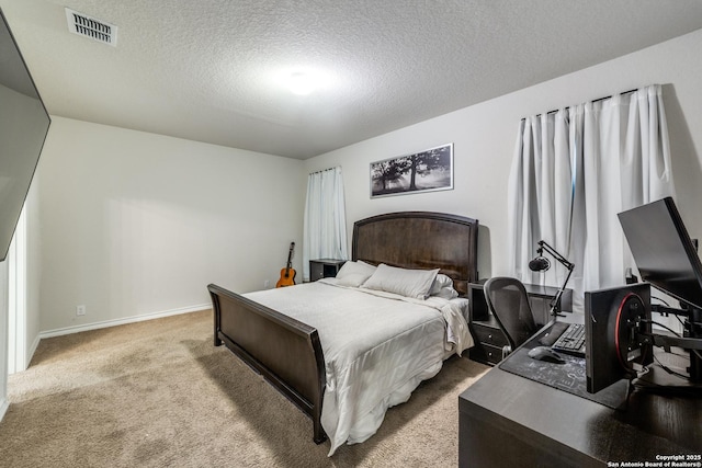 bedroom with light carpet and a textured ceiling