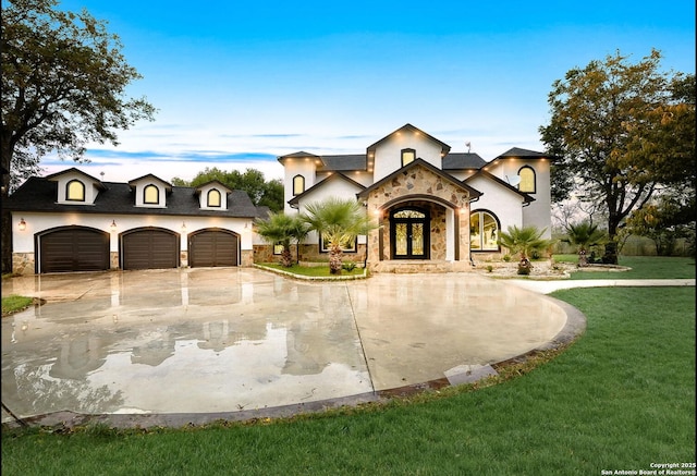 view of front of property with a garage, a front lawn, and french doors