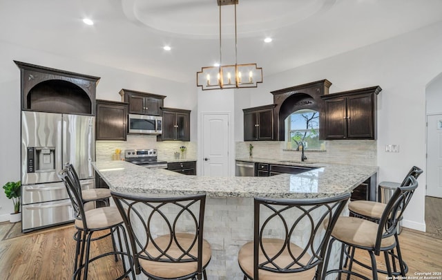 kitchen featuring sink, decorative light fixtures, a kitchen breakfast bar, and appliances with stainless steel finishes