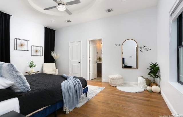 bedroom featuring a tray ceiling, ceiling fan, and hardwood / wood-style flooring