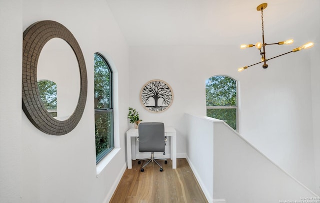 office space featuring wood-type flooring and a chandelier