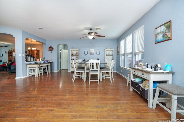 dining room featuring dark hardwood / wood-style flooring and ceiling fan with notable chandelier