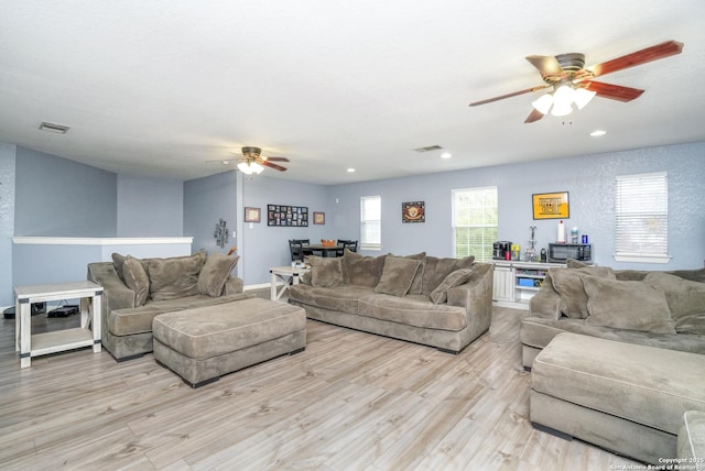 living room with light hardwood / wood-style floors and ceiling fan