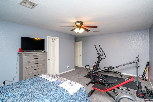 carpeted bedroom featuring ceiling fan and a textured ceiling