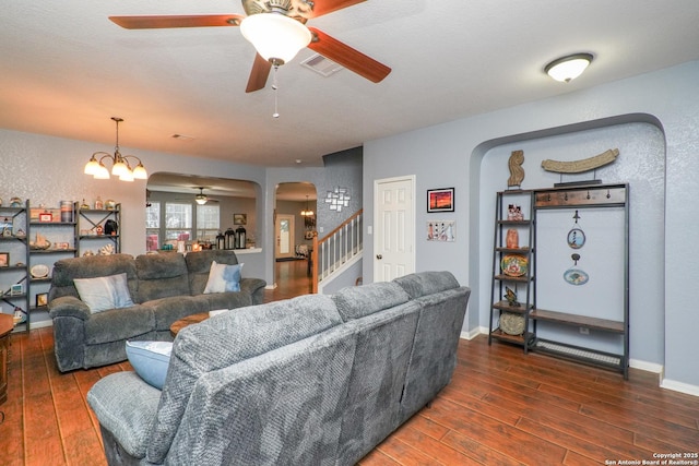 living room featuring dark hardwood / wood-style flooring and ceiling fan with notable chandelier