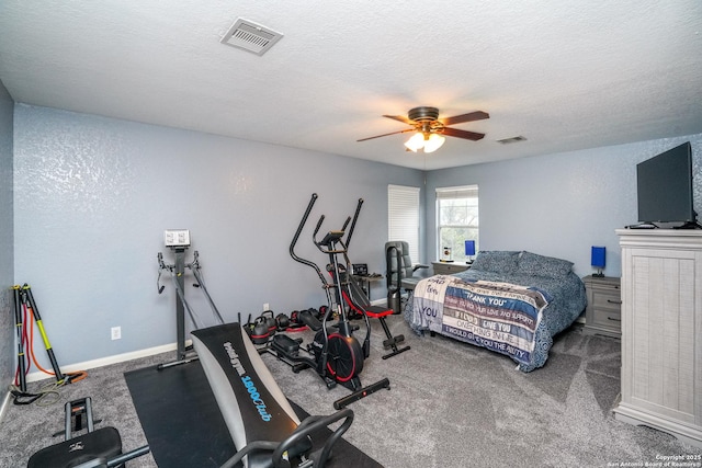 carpeted bedroom with ceiling fan and a textured ceiling