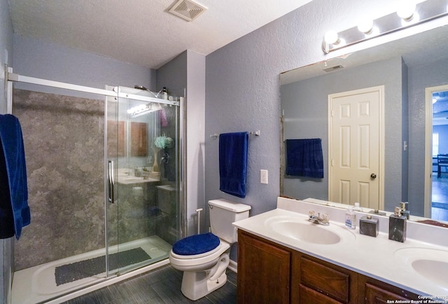 bathroom with vanity, an enclosed shower, a textured ceiling, and toilet