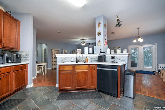 kitchen with sink, decorative light fixtures, kitchen peninsula, and black dishwasher