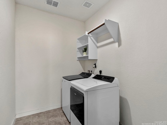 washroom with washer and clothes dryer and light tile patterned floors