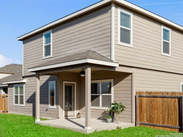 rear view of property featuring a yard, a patio area, and ceiling fan