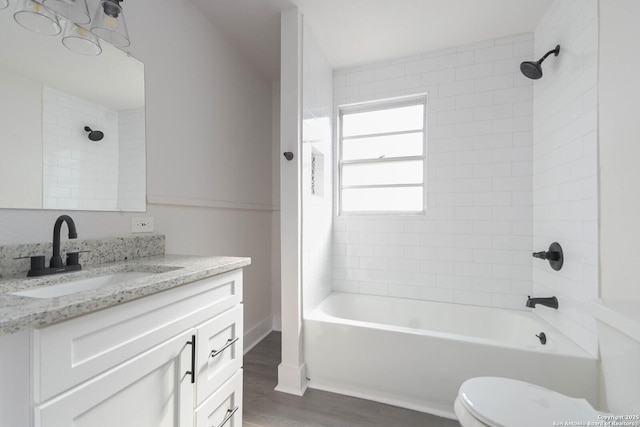 full bathroom featuring vanity, tiled shower / bath combo, wood-type flooring, and toilet