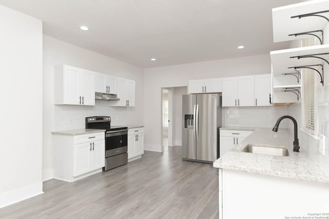 kitchen featuring white cabinetry, sink, light stone counters, and appliances with stainless steel finishes