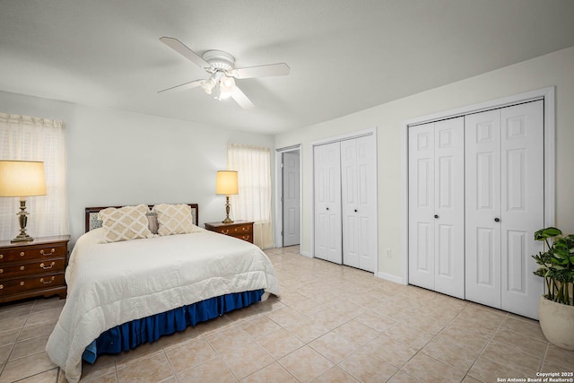 bedroom featuring ceiling fan, light tile patterned floors, and two closets