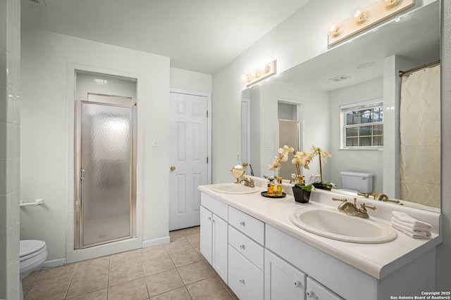 bathroom with vanity, toilet, tile patterned flooring, and a shower